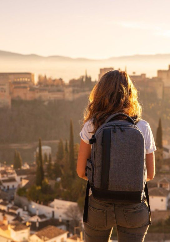 Woman with her backpack enjoying the views from the viewpoint of the city of Granada on one of our private tours.