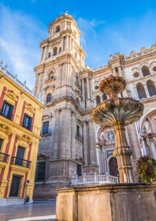 Facade of the Cathedral of Malaga with the fountain that decorates its entrance square as we can see on the private tour of the city.