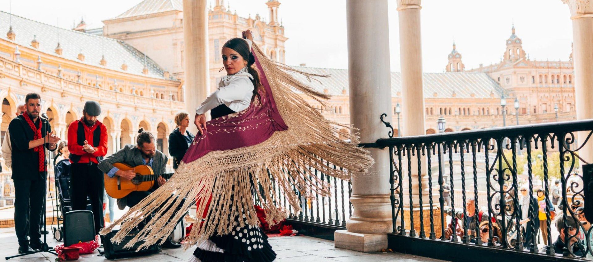 Flamenco group with a girl dancing in her flamenco dress and with the traditional shall.