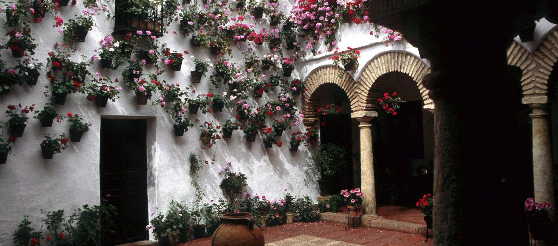 Interior of a typical Cordoba house with its flowers completely decorating the walls and arches that frame the space we visited during our visit of the courtyards.