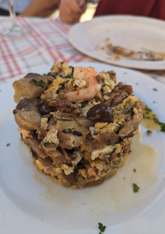 One tapa dish of scramble eggs with prawns and mushrooms in the shape of a cube and flavorful spices that you should try.