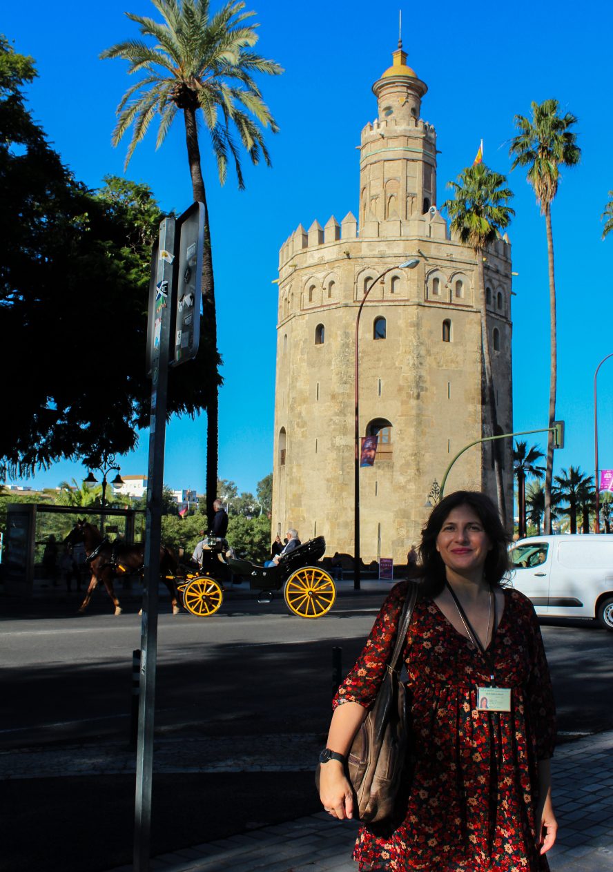 Photo of Alexia standing in front of the Torre del Oro monument in Seville at the beginning of the experience.